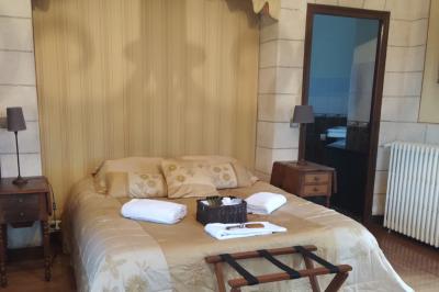 Salon avec canapé et chaises en velours rouge, table basse en bois, lampe sur pied et tableau au mur.