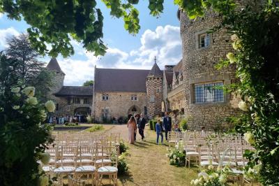 Salon avec canapé et chaises en velours rouge, table basse en bois, lampe sur pied et tableau au mur.