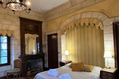 Salon avec canapé et chaises en velours rouge, table basse en bois, lampe sur pied et tableau au mur.