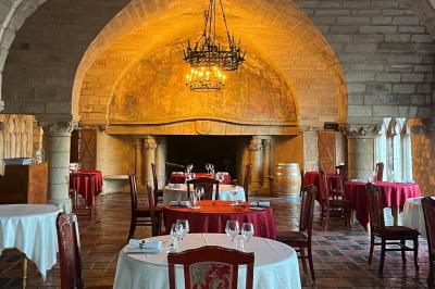 Salon avec canapé et chaises en velours rouge, table basse en bois, lampe sur pied et tableau au mur.