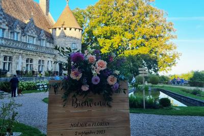 Salon avec canapé et chaises en velours rouge, table basse en bois, lampe sur pied et tableau au mur.