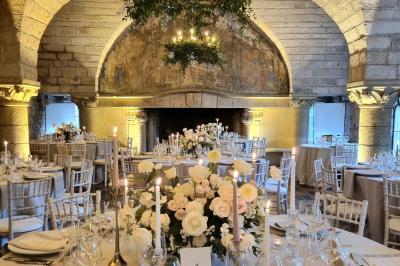 Salon avec canapé et chaises en velours rouge, table basse en bois, lampe sur pied et tableau au mur.