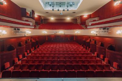 Façade du Théâtre Saint-Georges dans une rue calme avec des passants et des bâtiments environnants.
