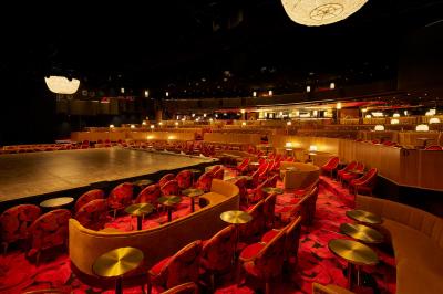 Intérieur d'une pièce aux motifs colorés et symétriques avec des murs en bois, des miroirs et un plafond lumineux.
