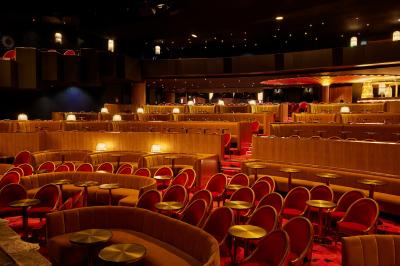 Intérieur d'une pièce aux motifs colorés et symétriques avec des murs en bois, des miroirs et un plafond lumineux.