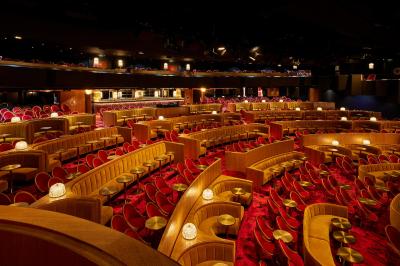 Intérieur d'une pièce aux motifs colorés et symétriques avec des murs en bois, des miroirs et un plafond lumineux.