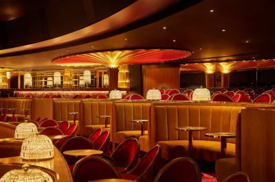 Intérieur d'une pièce aux motifs colorés et symétriques avec des murs en bois, des miroirs et un plafond lumineux.