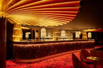 Intérieur d'une pièce aux motifs colorés et symétriques avec des murs en bois, des miroirs et un plafond lumineux.