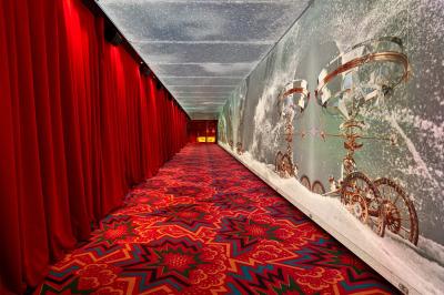 Intérieur d'une pièce aux motifs colorés et symétriques avec des murs en bois, des miroirs et un plafond lumineux.