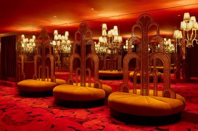 Intérieur d'une pièce aux motifs colorés et symétriques avec des murs en bois, des miroirs et un plafond lumineux.