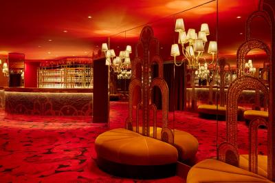 Intérieur d'une pièce aux motifs colorés et symétriques avec des murs en bois, des miroirs et un plafond lumineux.