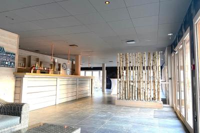 Chambre avec deux lits simples, tablettes de chevet, lampes, parquet et balcon donnant sur un paysage extérieur.