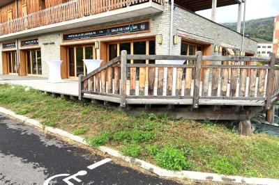 Chambre avec deux lits simples, tablettes de chevet, lampes, parquet et balcon donnant sur un paysage extérieur.
