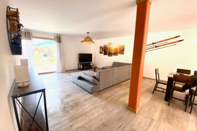 Chambre avec deux lits simples, tablettes de chevet, lampes, parquet et balcon donnant sur un paysage extérieur.