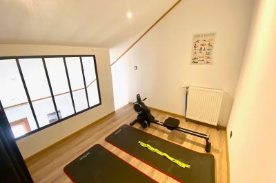 Chambre avec deux lits simples, tablettes de chevet, lampes, parquet et balcon donnant sur un paysage extérieur.