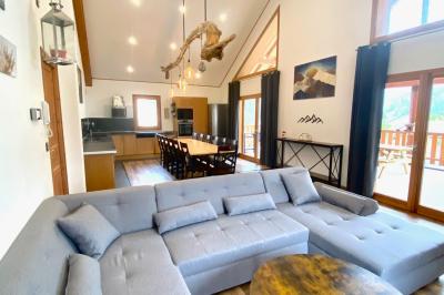 Chambre avec deux lits simples, tablettes de chevet, lampes, parquet et balcon donnant sur un paysage extérieur.