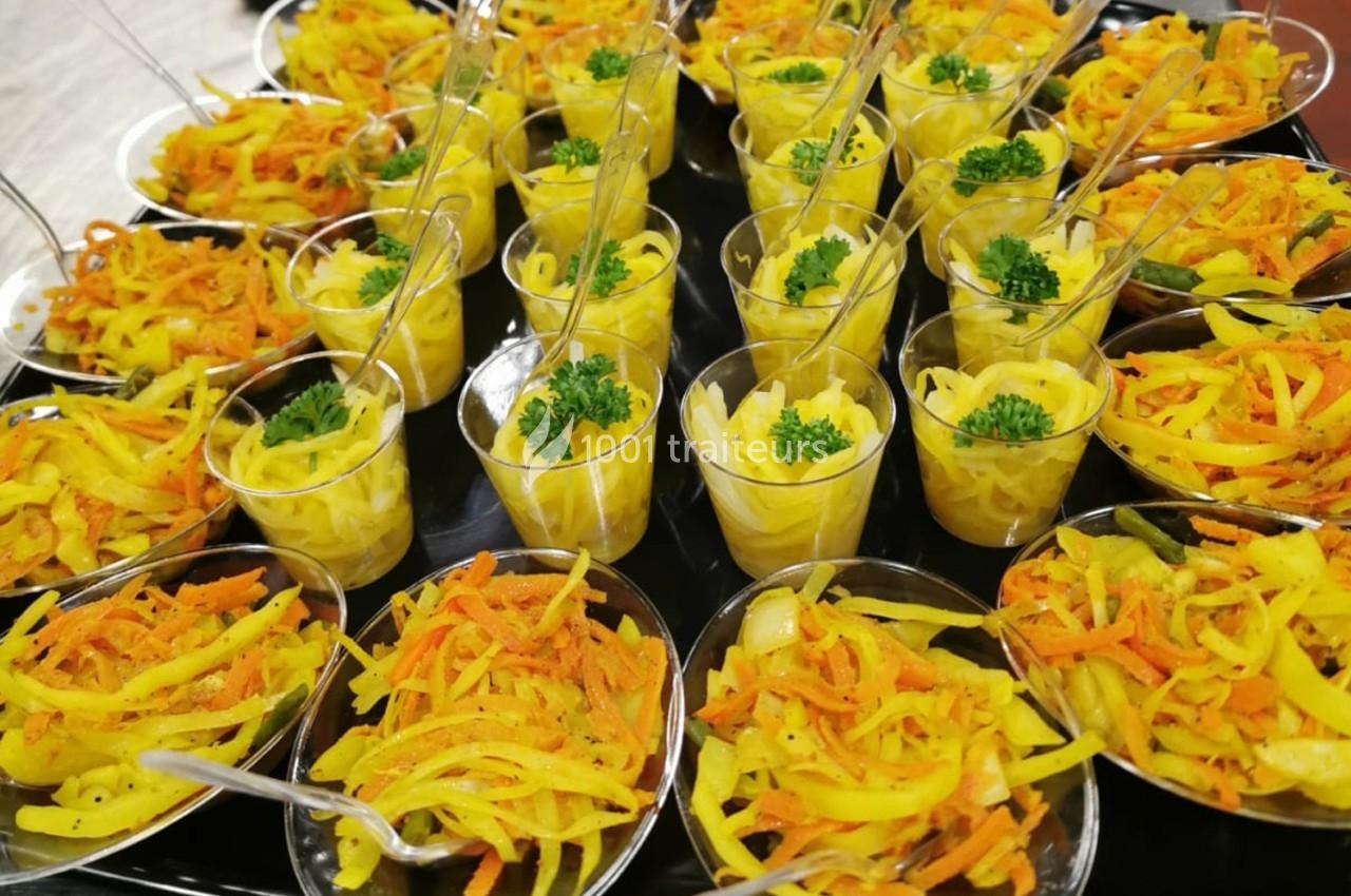 Coupes individuelles de salade de carottes et de légumes jaunes garnies de persil, présentées sur un plateau.
