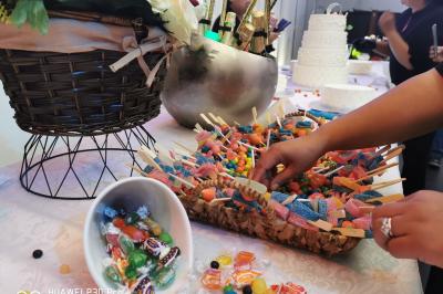 Miniature Traiteur Magny-les-Hameaux (Yvelines) - Iles en Fete #9 Plateau de charcuterie et fromages avec fruits, légumes et une bouteille de vin rouge, présenté sur une table en extérieur.