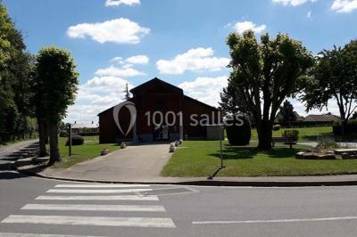 Toilettes avec lavabo, miroir, distributeur de papier, poubelle et carrelage au sol dans un espace restreint.