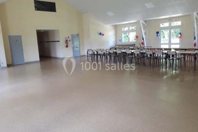 Toilettes avec lavabo, miroir, distributeur de papier, poubelle et carrelage au sol dans un espace restreint.