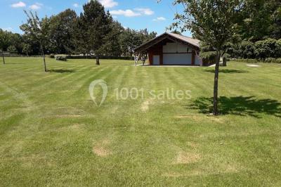 Toilettes avec lavabo, miroir, distributeur de papier, poubelle et carrelage au sol dans un espace restreint.