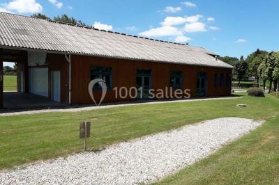 Toilettes avec lavabo, miroir, distributeur de papier, poubelle et carrelage au sol dans un espace restreint.