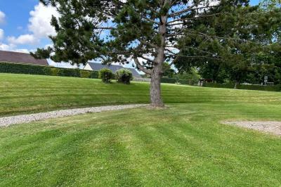 Toilettes avec lavabo, miroir, distributeur de papier, poubelle et carrelage au sol dans un espace restreint.