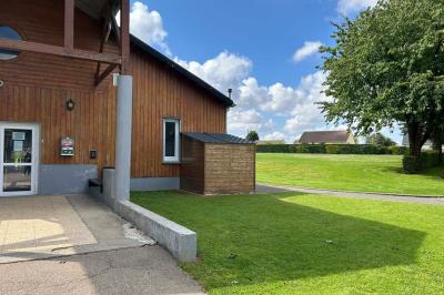 Toilettes avec lavabo, miroir, distributeur de papier, poubelle et carrelage au sol dans un espace restreint.