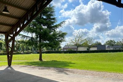 Toilettes avec lavabo, miroir, distributeur de papier, poubelle et carrelage au sol dans un espace restreint.