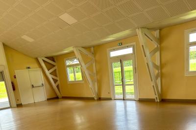 Toilettes avec lavabo, miroir, distributeur de papier, poubelle et carrelage au sol dans un espace restreint.