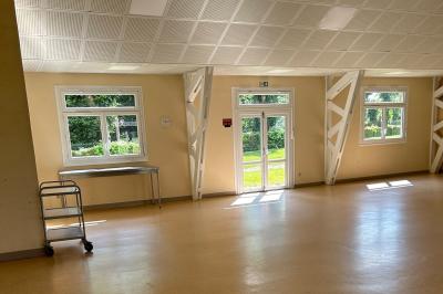 Toilettes avec lavabo, miroir, distributeur de papier, poubelle et carrelage au sol dans un espace restreint.