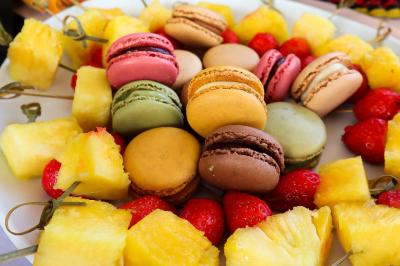 Plateau de charcuterie et fromages avec fruits, légumes, et une bouteille de vin rouge, sur une table en extérieur la nuit.