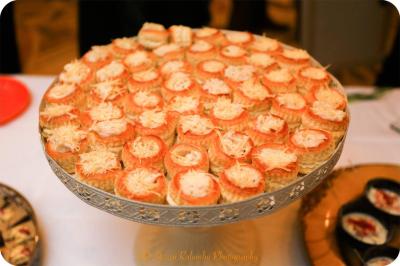 Plateau de charcuterie et fromages avec fruits, légumes, et une bouteille de vin rouge, sur une table en extérieur la nuit.
