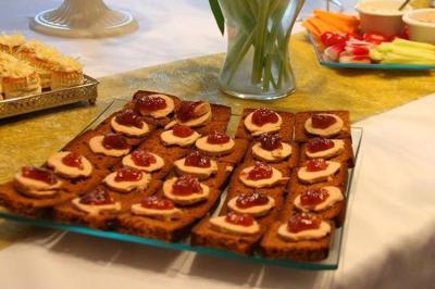 Plateau de charcuterie et fromages avec fruits, légumes, et une bouteille de vin rouge, sur une table en extérieur la nuit.