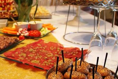 Plateau de charcuterie et fromages avec fruits, légumes, et une bouteille de vin rouge, sur une table en extérieur la nuit.