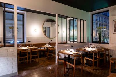 Pizza margherita sortant d'un four à bois avec une façade en mosaïque noire et l'inscription ’N° 900’.