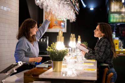 Pizza margherita sortant d'un four à bois avec une façade en mosaïque noire et l'inscription ’N° 900’.