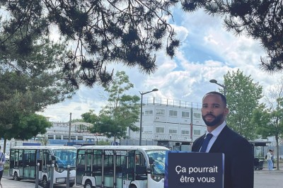 Alignement de véhicules noirs stationnés devant un bâtiment en pierre avec arcades, sous un ciel dégagé.