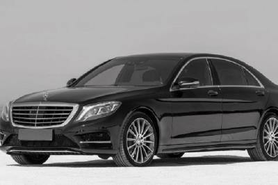 Fourgonnette noire avec portes latérales et arrière ouvertes, montrant un siège accessible et une rampe déployée.