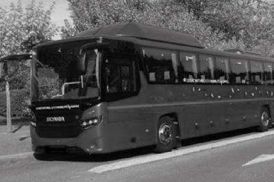 Fourgonnette noire avec portes latérales et arrière ouvertes, montrant un siège accessible et une rampe déployée.