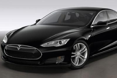 Fourgonnette noire avec portes latérales et arrière ouvertes, montrant un siège accessible et une rampe déployée.