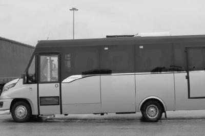 Fourgonnette noire avec portes latérales et arrière ouvertes, montrant un siège accessible et une rampe déployée.