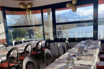 Deux cocktails colorés et une assiette d'olives sur une table en bois, avec un coucher de soleil en arrière-plan.