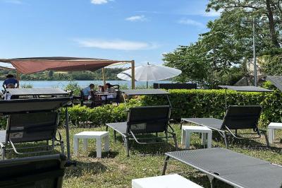 Deux cocktails colorés et une assiette d'olives sur une table en bois, avec un coucher de soleil en arrière-plan.