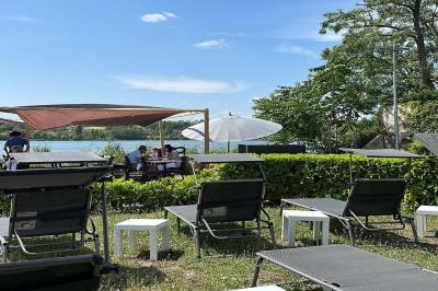 Deux cocktails colorés et une assiette d'olives sur une table en bois, avec un coucher de soleil en arrière-plan.