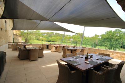 Buffet élégant en extérieur avec tables rondes garnies de verrines, fleurs et amuse-bouches sous des parasols.