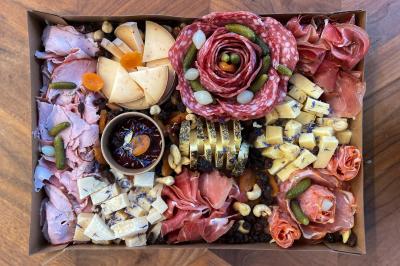 Sandwiches colorés empilés avec des garnitures variées, entourés de roquette et d'olives vertes.