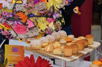 Sandwiches colorés empilés avec des garnitures variées, entourés de roquette et d'olives vertes.