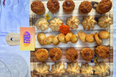 Sandwiches colorés empilés avec des garnitures variées, entourés de roquette et d'olives vertes.