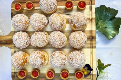 Sandwiches colorés empilés avec des garnitures variées, entourés de roquette et d'olives vertes.